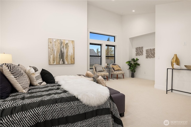 bedroom with light carpet, a high ceiling, recessed lighting, and baseboards