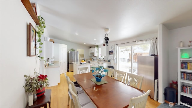 dining space featuring recessed lighting, vaulted ceiling, and light wood-style flooring