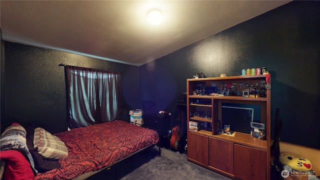 bedroom featuring carpet floors and a textured wall