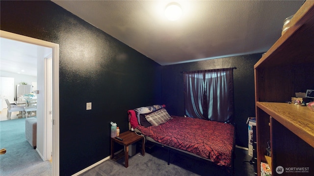 bedroom with carpet floors and a textured wall