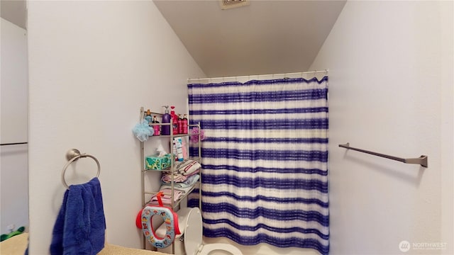 bathroom featuring toilet, visible vents, and a shower with shower curtain