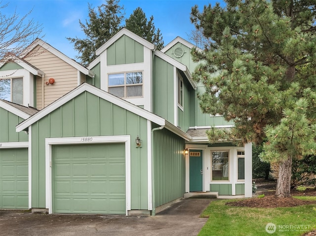 mid-century home with a garage, roof with shingles, and board and batten siding