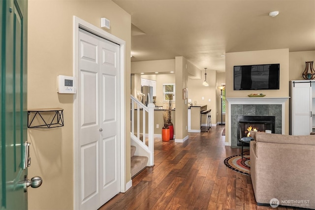 interior space with stairs, baseboards, wood-type flooring, and a fireplace