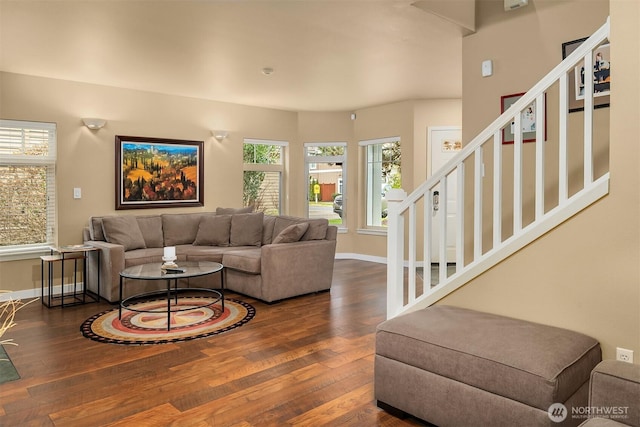 living room with baseboards, hardwood / wood-style floors, and stairs