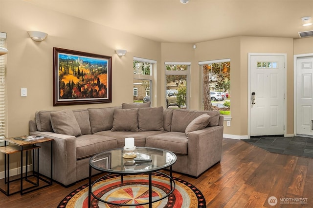 living room featuring visible vents, baseboards, and dark wood finished floors