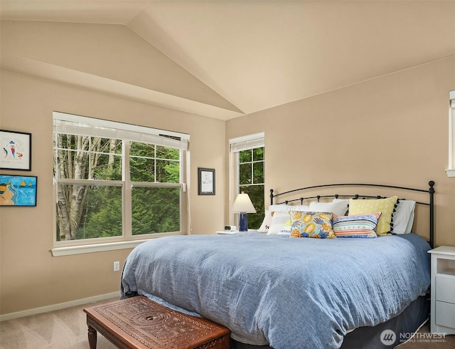 carpeted bedroom with baseboards and vaulted ceiling