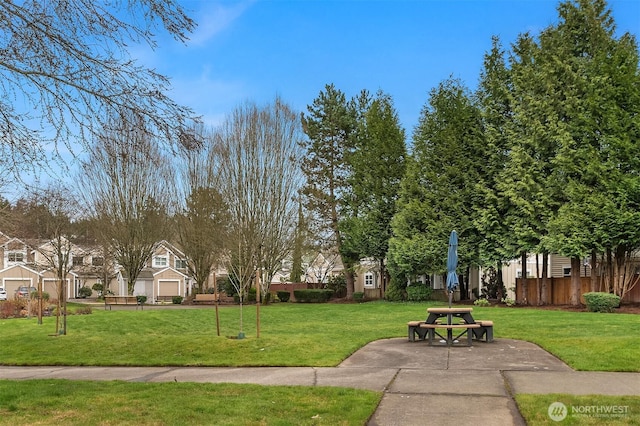 view of community with a lawn and fence