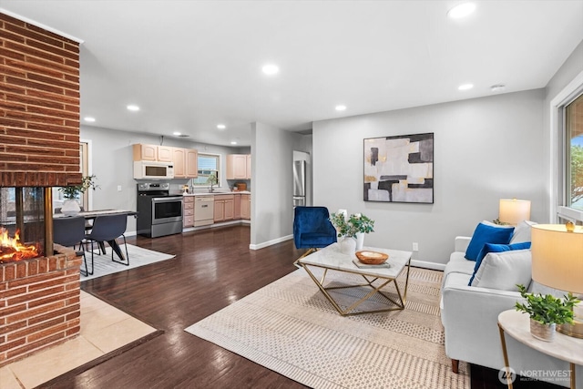 living area with plenty of natural light, recessed lighting, baseboards, and dark wood-style flooring