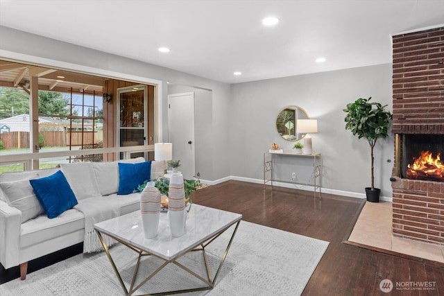 living room featuring a fireplace, recessed lighting, wood finished floors, and baseboards