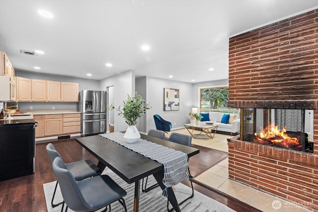 dining space with recessed lighting, visible vents, dark wood finished floors, and a fireplace