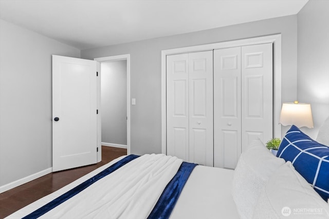 bedroom with a closet, baseboards, and wood finished floors