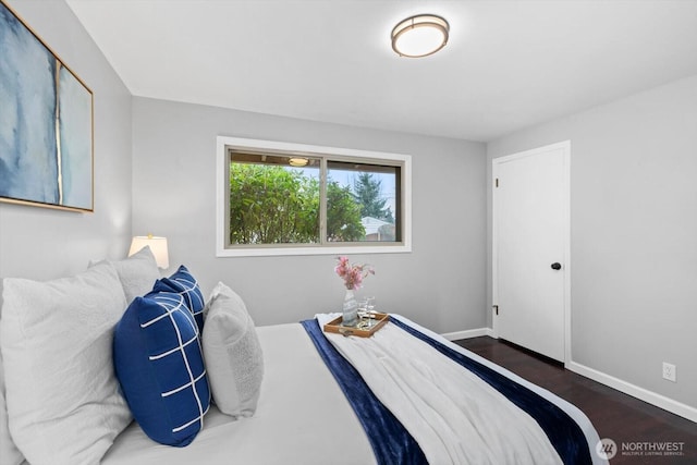 bedroom with wood finished floors and baseboards