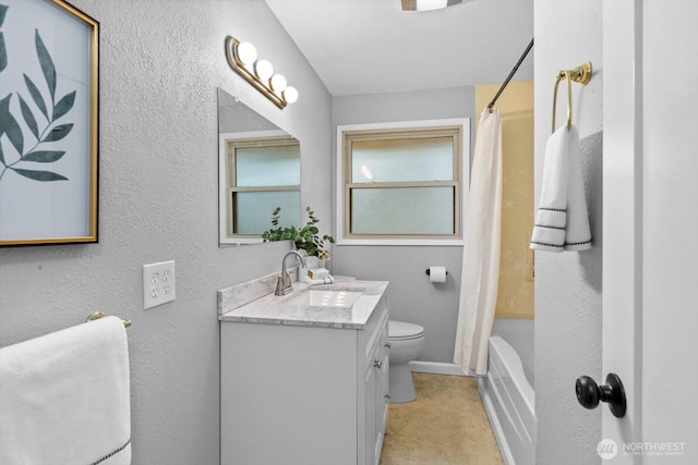 full bath with toilet, shower / bath combination with curtain, vanity, and a textured wall