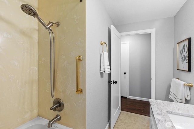 bathroom featuring vanity, bathing tub / shower combination, and baseboards