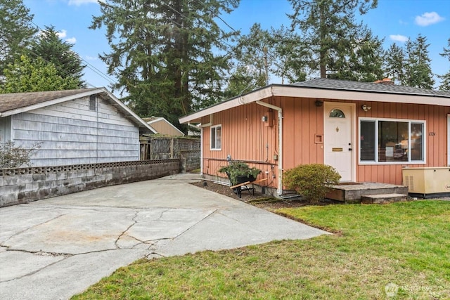 exterior space with a front yard, fence, and a patio area