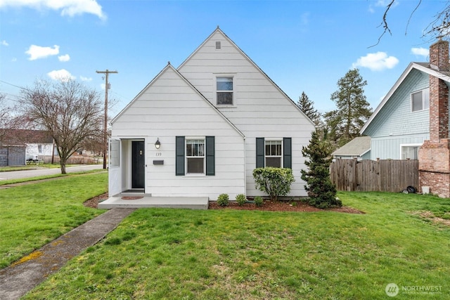 bungalow-style house with a front yard and fence