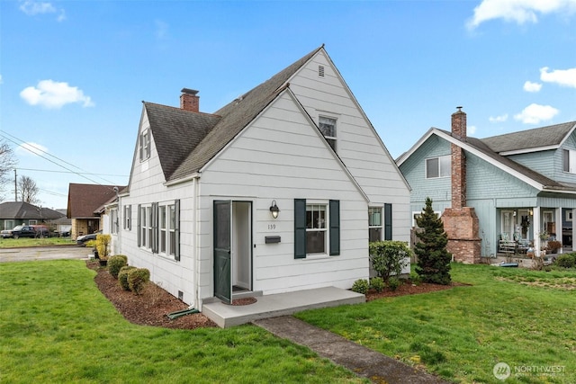 view of front facade featuring a front yard, roof with shingles, and a chimney