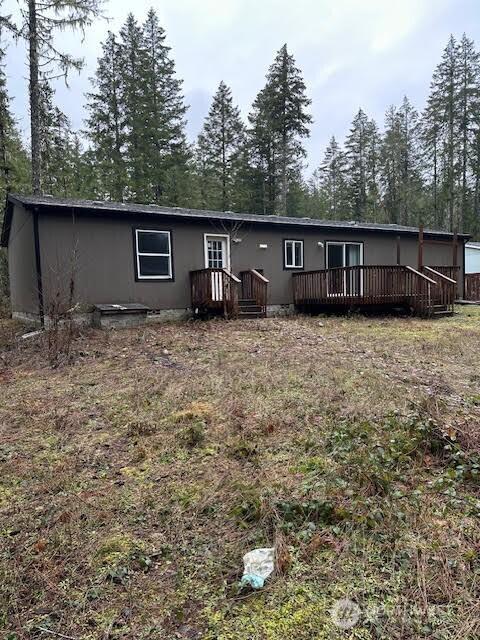 rear view of house featuring a wooden deck