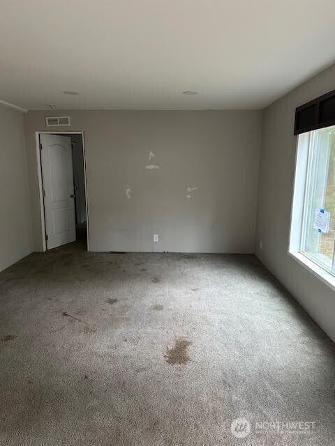 unfurnished room with carpet floors and visible vents