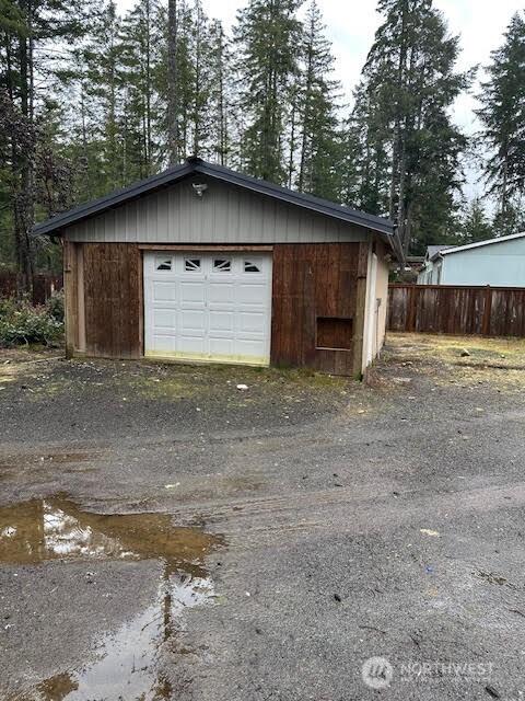 detached garage with driveway and fence