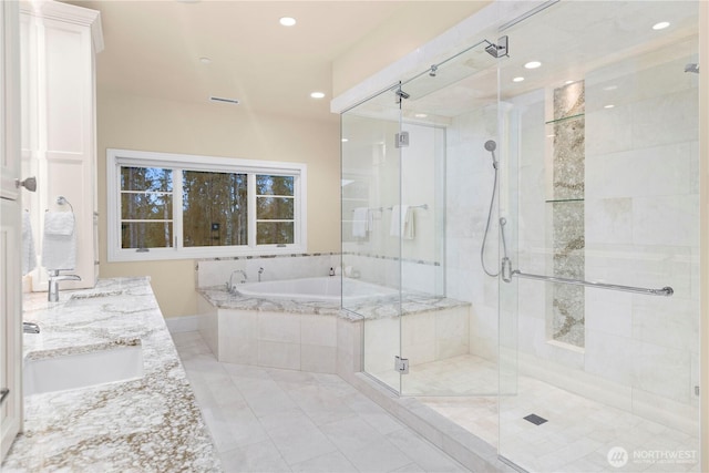 full bathroom featuring a bath, a stall shower, a sink, and recessed lighting