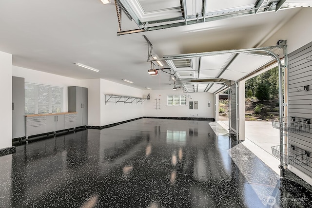 garage with a garage door opener and baseboards