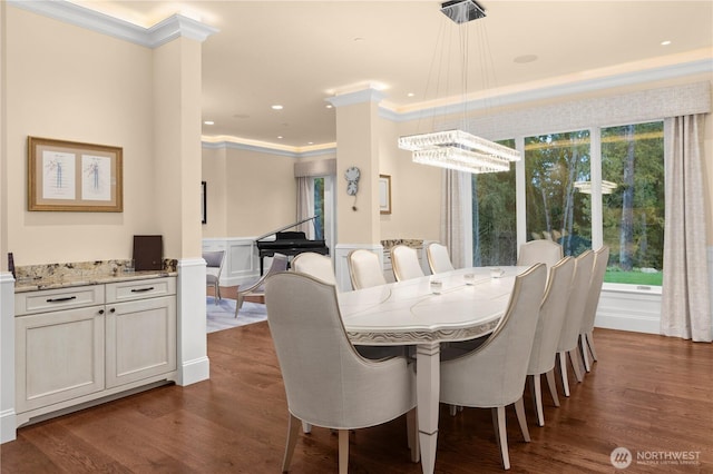 dining space with dark wood-style floors, ornamental molding, and a healthy amount of sunlight