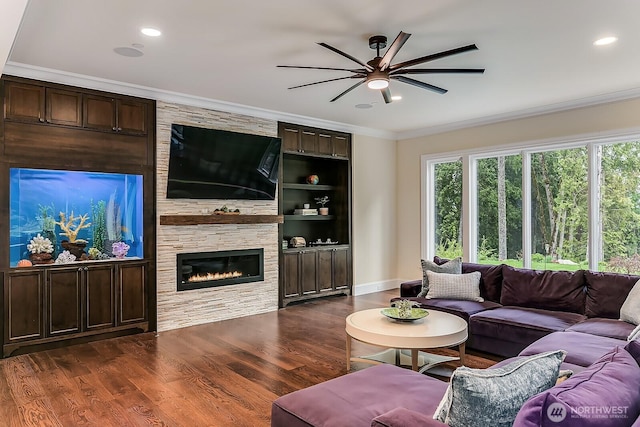 living room featuring dark wood-style floors, recessed lighting, a fireplace, and crown molding