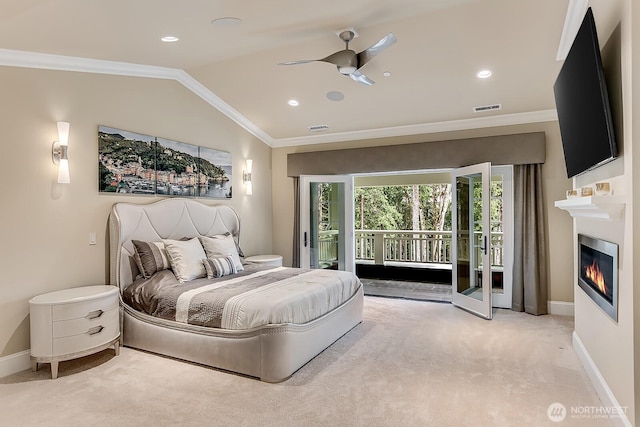 bedroom with carpet floors, access to exterior, ornamental molding, vaulted ceiling, and a warm lit fireplace