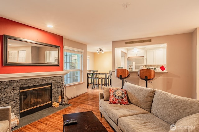 living area with a fireplace and wood finished floors