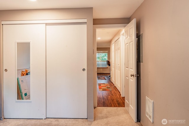 hall featuring visible vents and carpet flooring