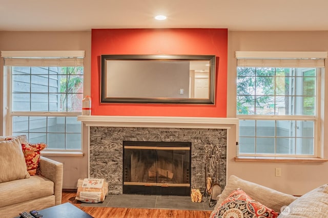 living room with recessed lighting, wood finished floors, and a glass covered fireplace