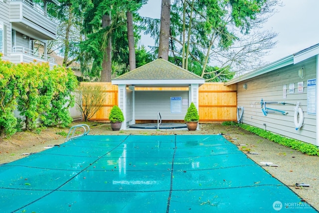 view of swimming pool with a fenced in pool, fence, and an outdoor structure