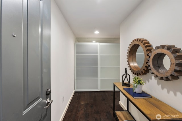 corridor featuring baseboards, dark wood-type flooring, and recessed lighting