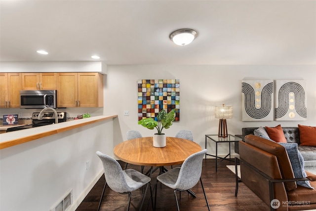 dining room with dark wood-style floors, baseboards, visible vents, and recessed lighting