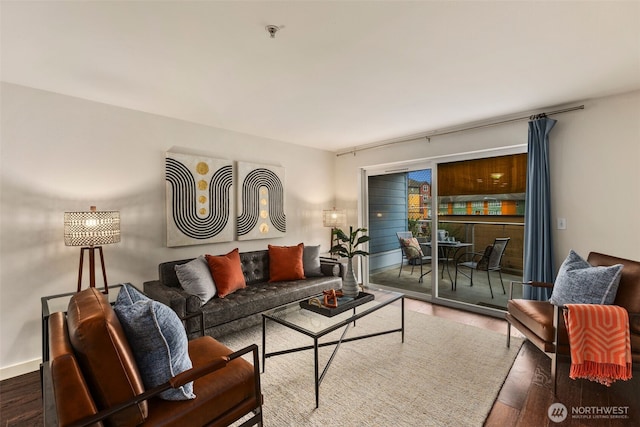 living area with baseboards and wood finished floors