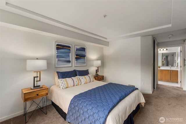 carpeted bedroom with a tray ceiling, visible vents, baseboards, and a sink