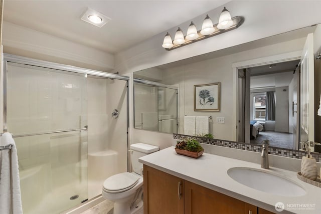 full bath with connected bathroom, toilet, a shower stall, and vanity