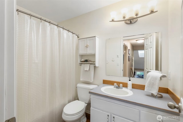 bathroom featuring a shower with curtain, vanity, and toilet