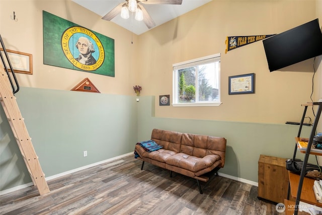 sitting room featuring a ceiling fan, baseboards, and wood finished floors