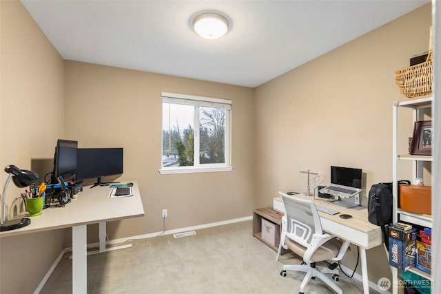 office featuring baseboards, visible vents, and light colored carpet