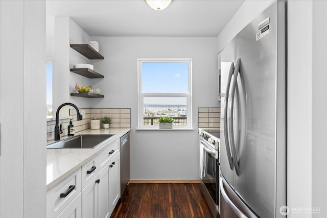 kitchen with dark wood-style flooring, open shelves, stainless steel appliances, backsplash, and a sink