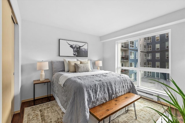 bedroom with a closet, wood finished floors, and baseboards