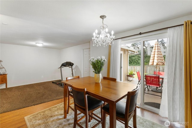 dining room with light wood-type flooring and an inviting chandelier