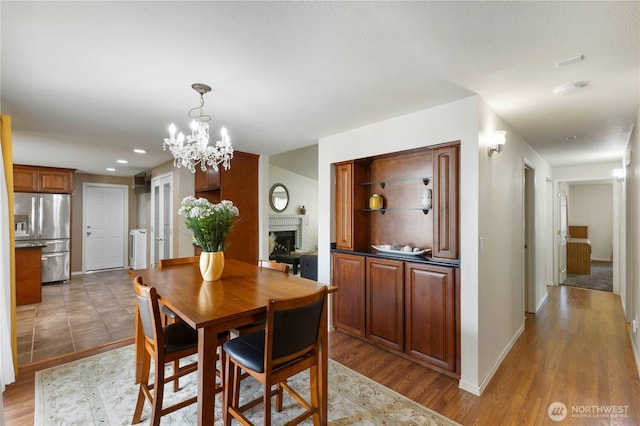 dining area featuring a fireplace, wood finished floors, washer / dryer, and baseboards