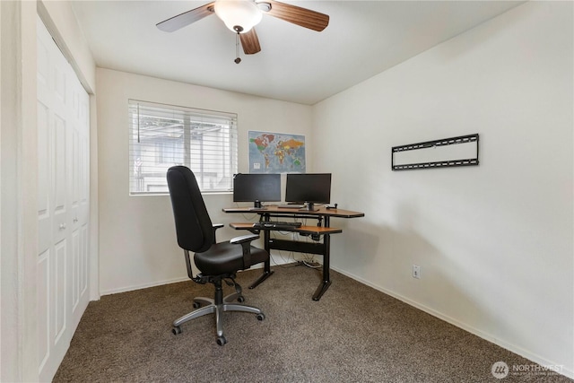 carpeted office with ceiling fan and baseboards