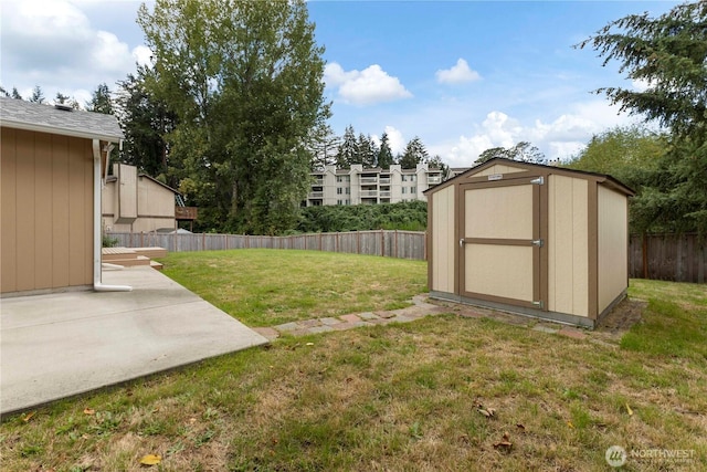 view of yard featuring an outbuilding, a shed, a patio area, and a fenced backyard