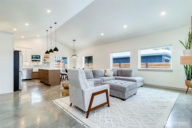 living area featuring high vaulted ceiling, finished concrete floors, baseboards, and recessed lighting