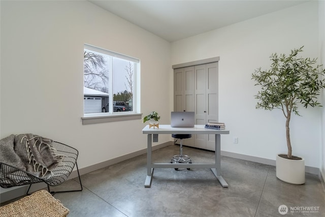 office space with finished concrete floors and baseboards