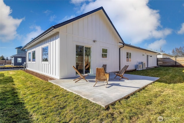 rear view of house featuring a yard, board and batten siding, a patio, and fence